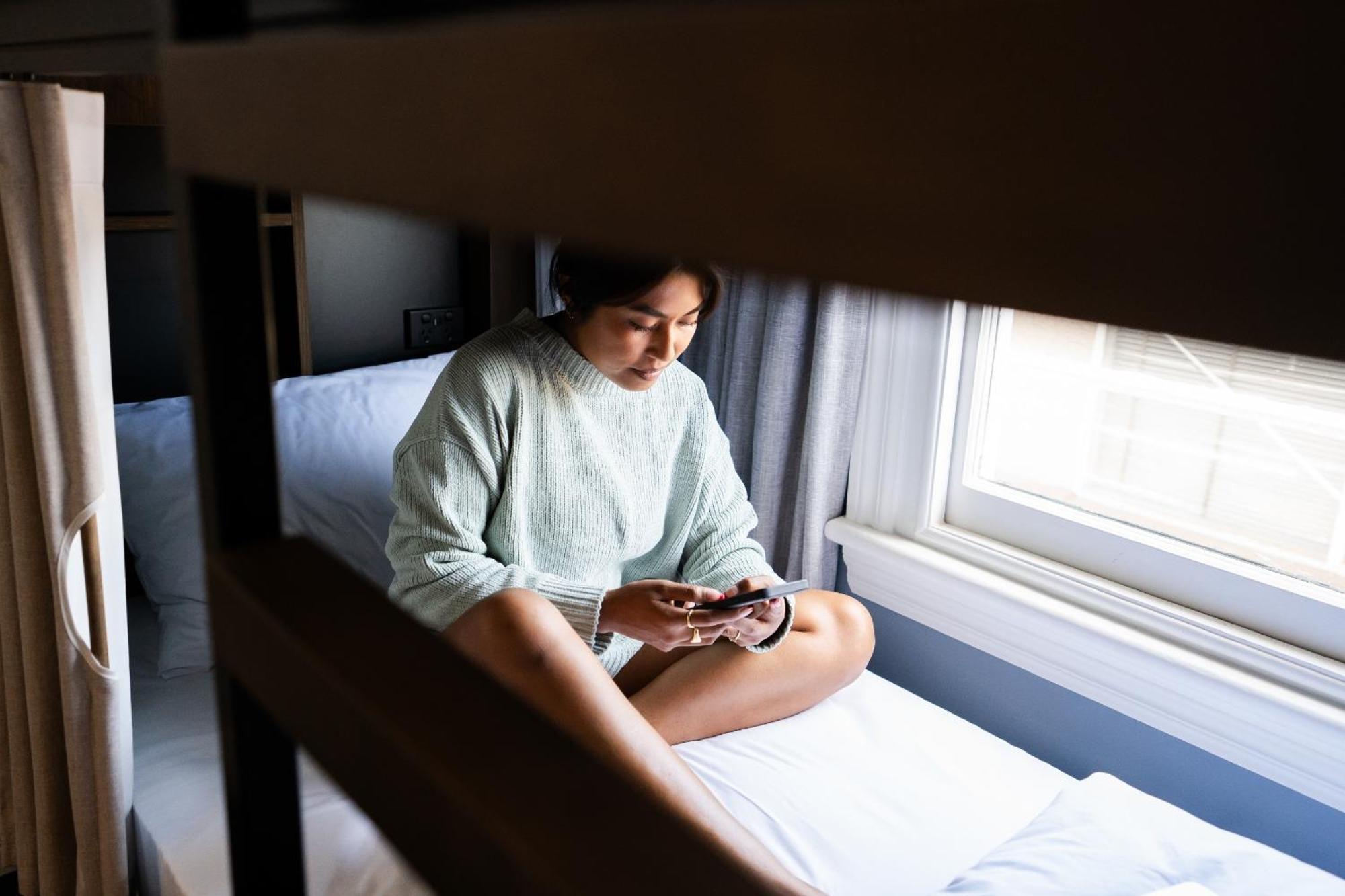 Albergue Haka House Wellington Exterior foto A woman sitting on a bunk bed
